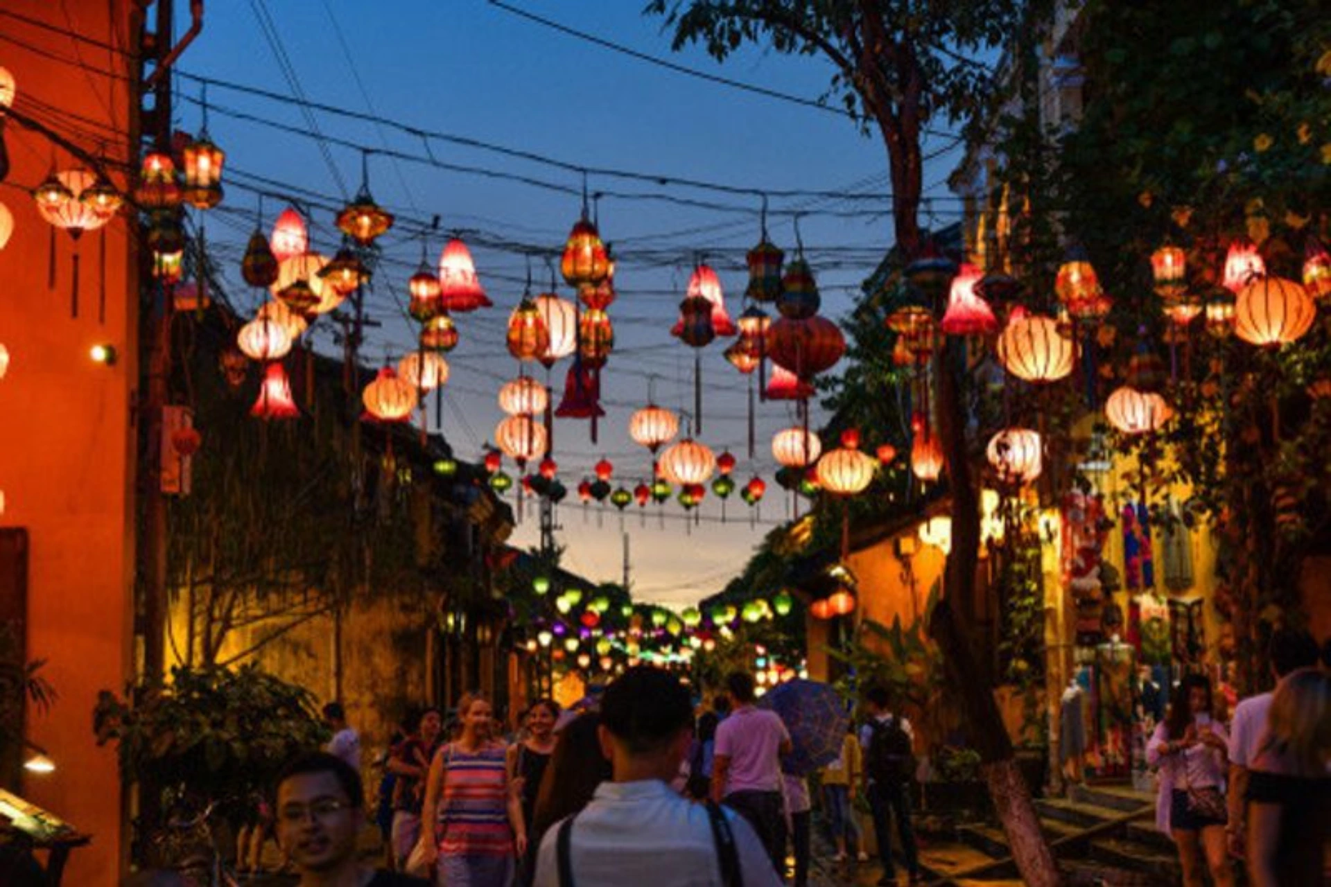 Hoi An street lit by red and orange hanging lanterns at dusk