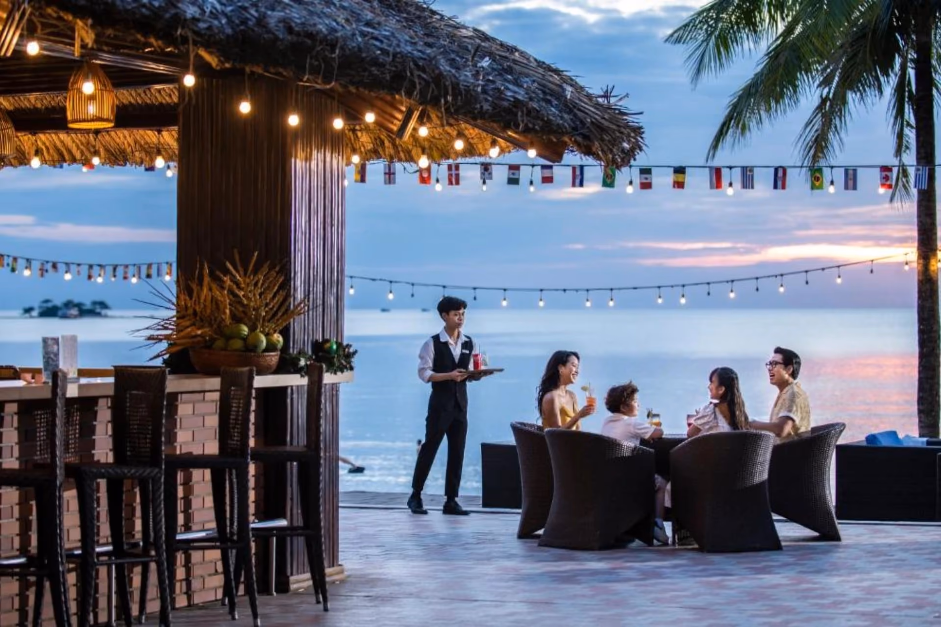 Group enjoying drinks at beachside bar, Vinepearl Phu Quoc