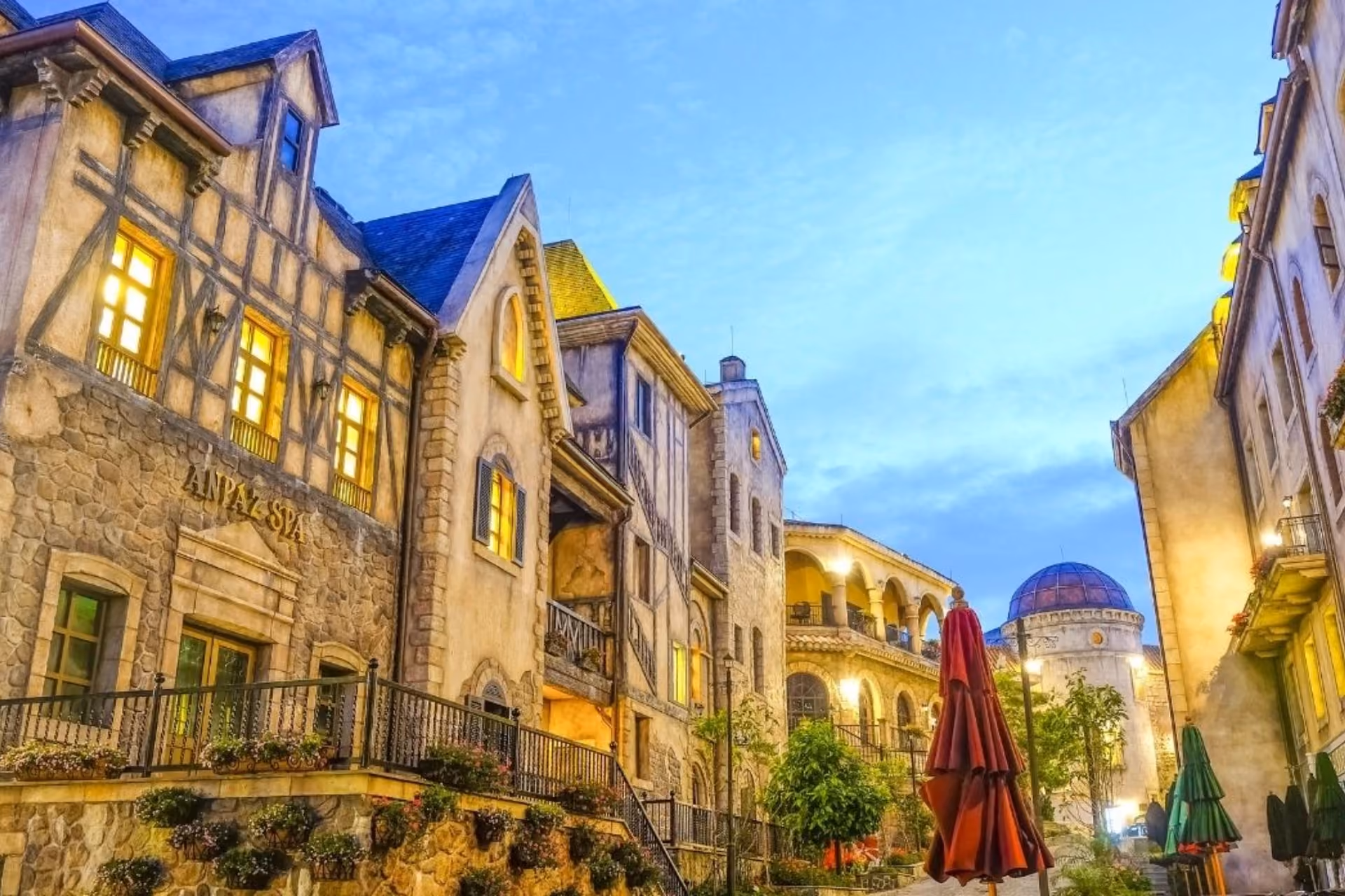 Historic stone buildings lit up at dusk in French village