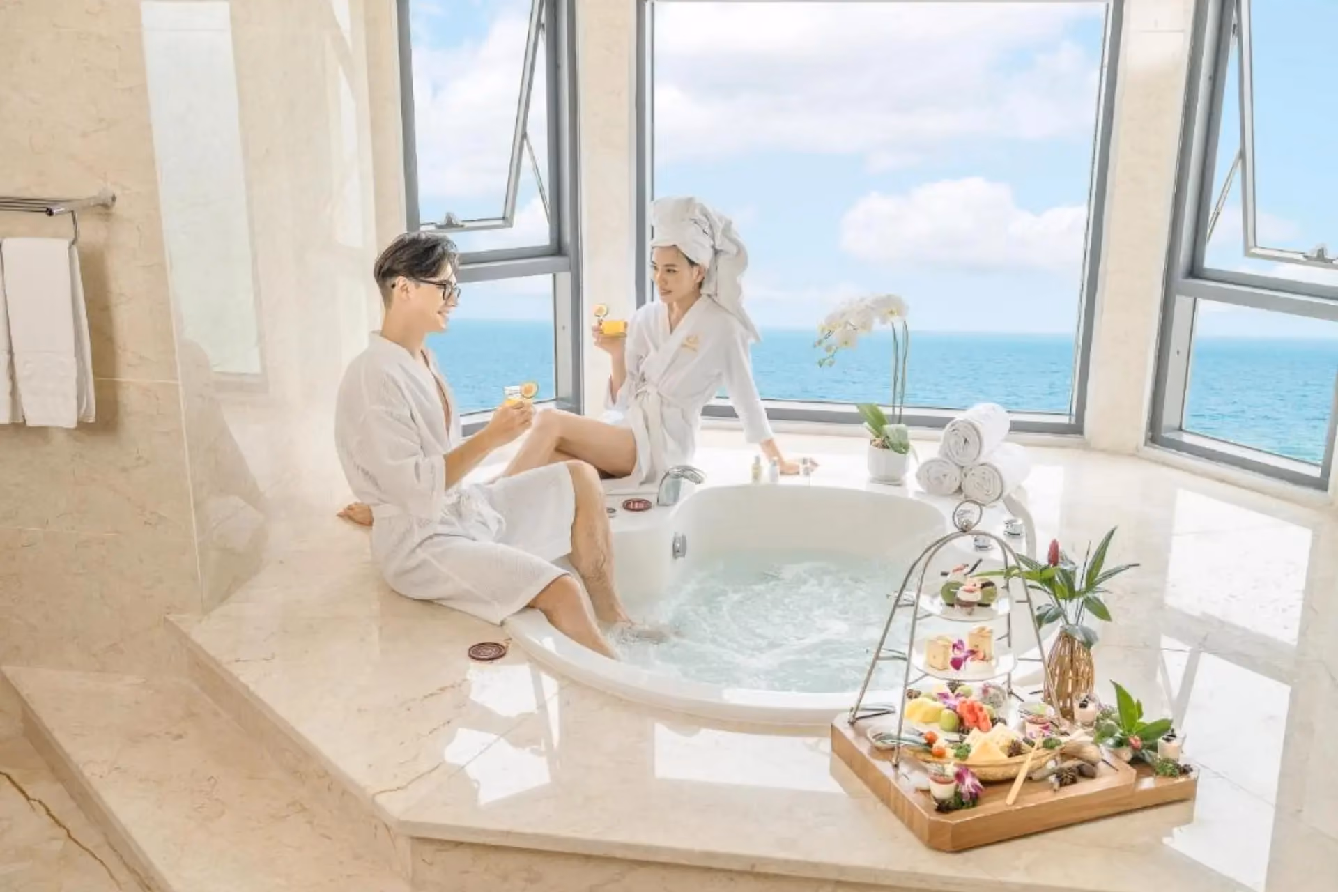Two people relaxing in bathtub at Dlg Hotel Da Nang with ocean view