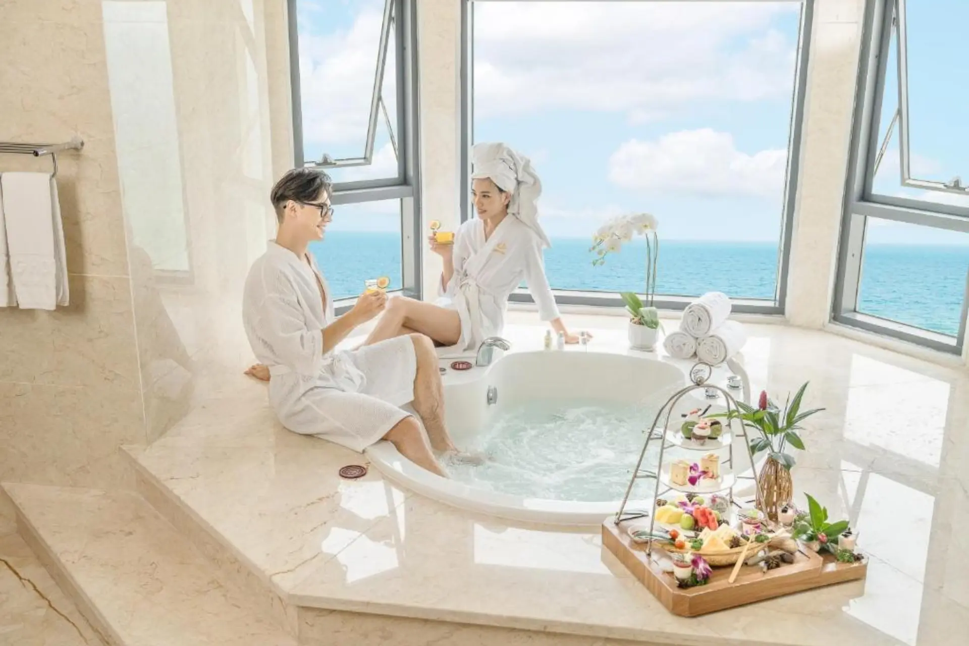 Two people relaxing in bathtub at Dlg Hotel Da Nang with ocean view