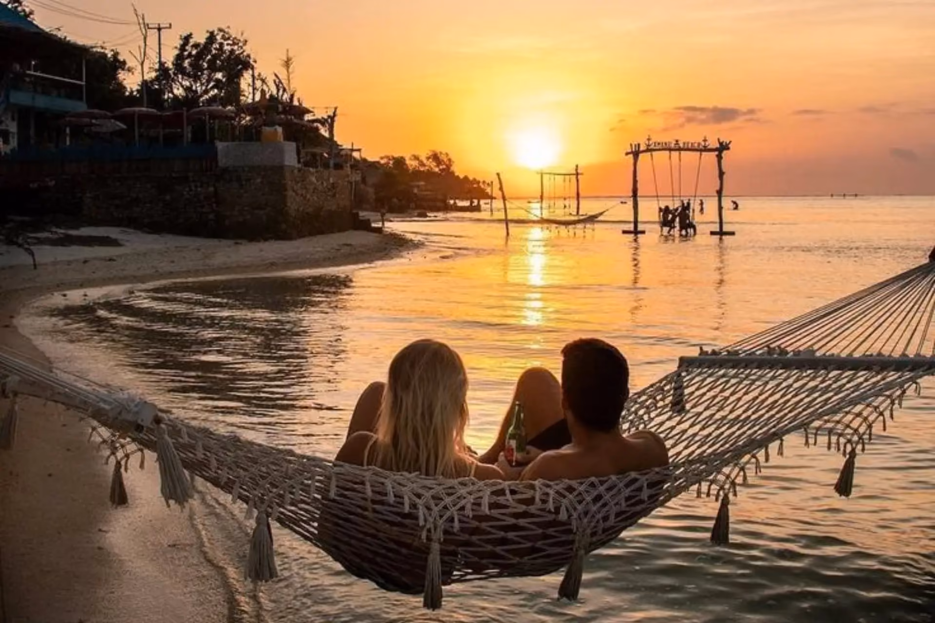 Couple relaxing in hammock at Gili Beach Bali sunset