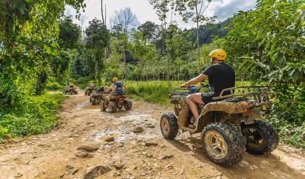 Group riding ATVs on muddy jungle trail in Phuket