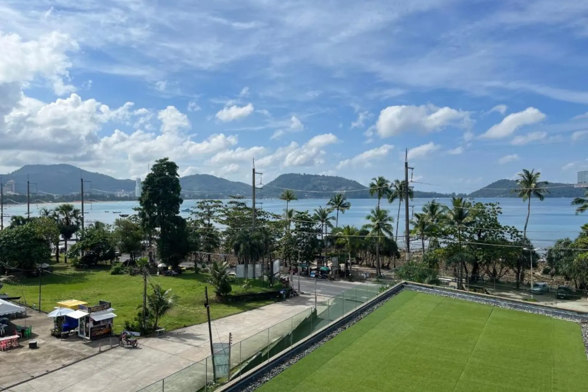 Green sports field overlooking bay and mountains in Phuket