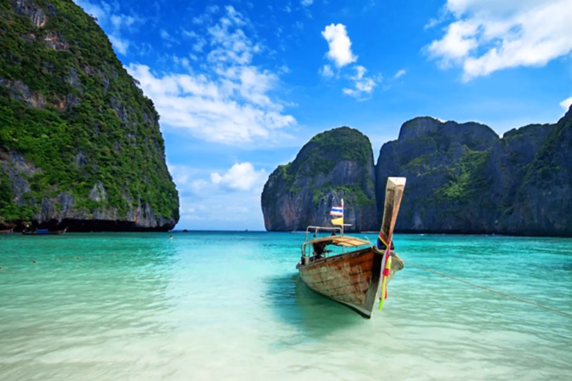 Wooden boat in clear water at Phuket Thailand