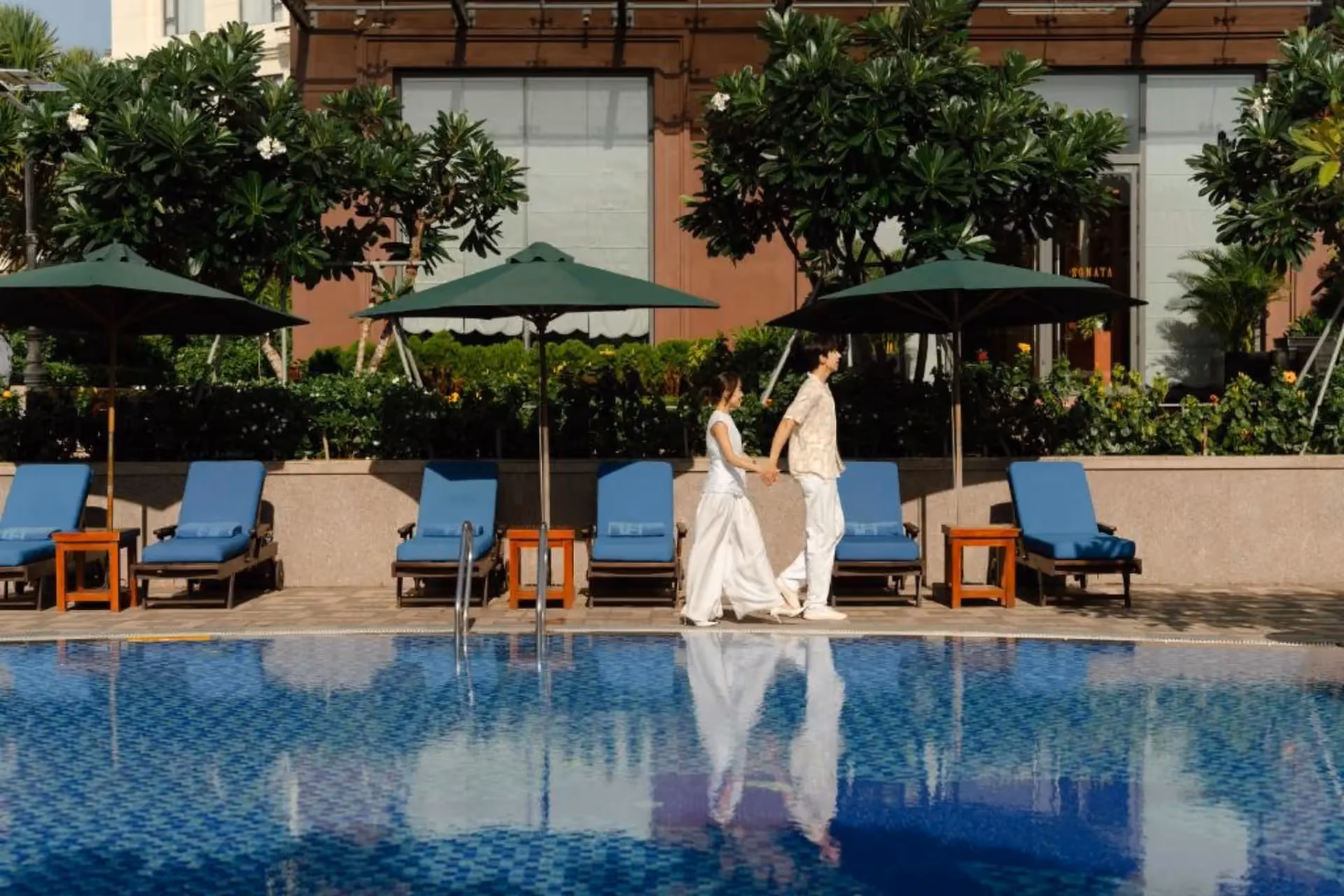 Couple walking by pool at Dlg Hotel Da Nang