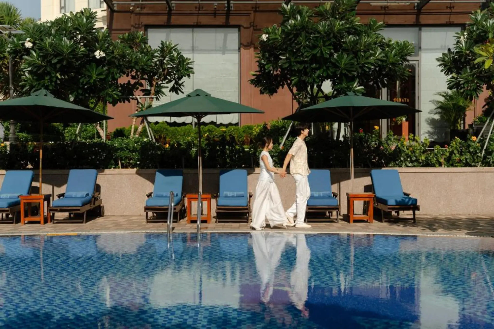 Couple walking by pool at Dlg Hotel Da Nang