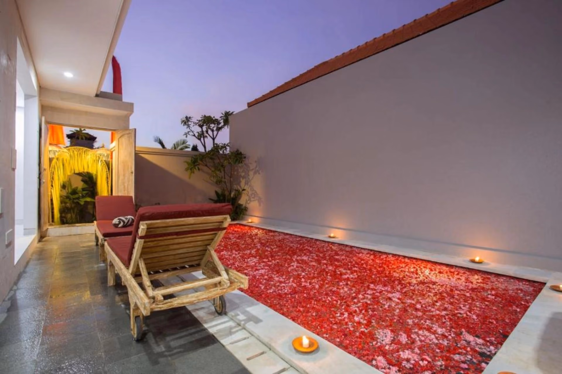 Awandari Villas Seminyak courtyard with red flower petals and lounge chairs