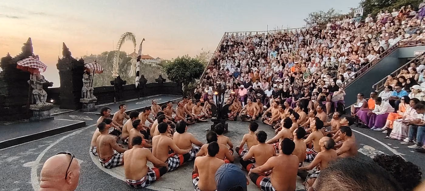 Kecak dance performers sitting in circle, Bali crowd watching