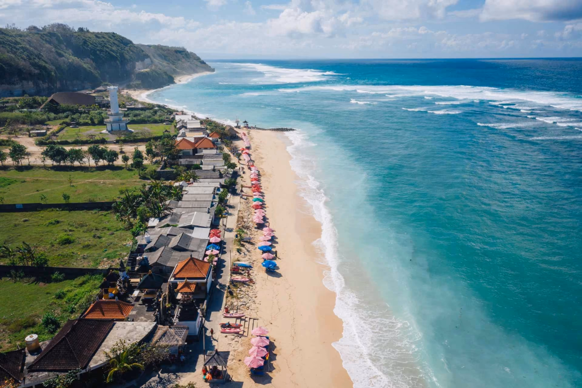 Pandawa Beach with colorful umbrellas and cliff views