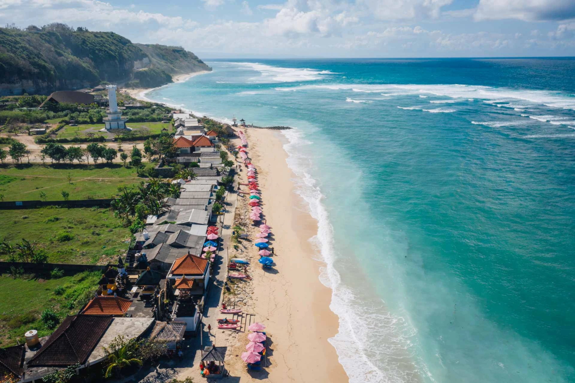 Pandawa Beach with colorful umbrellas and cliff views