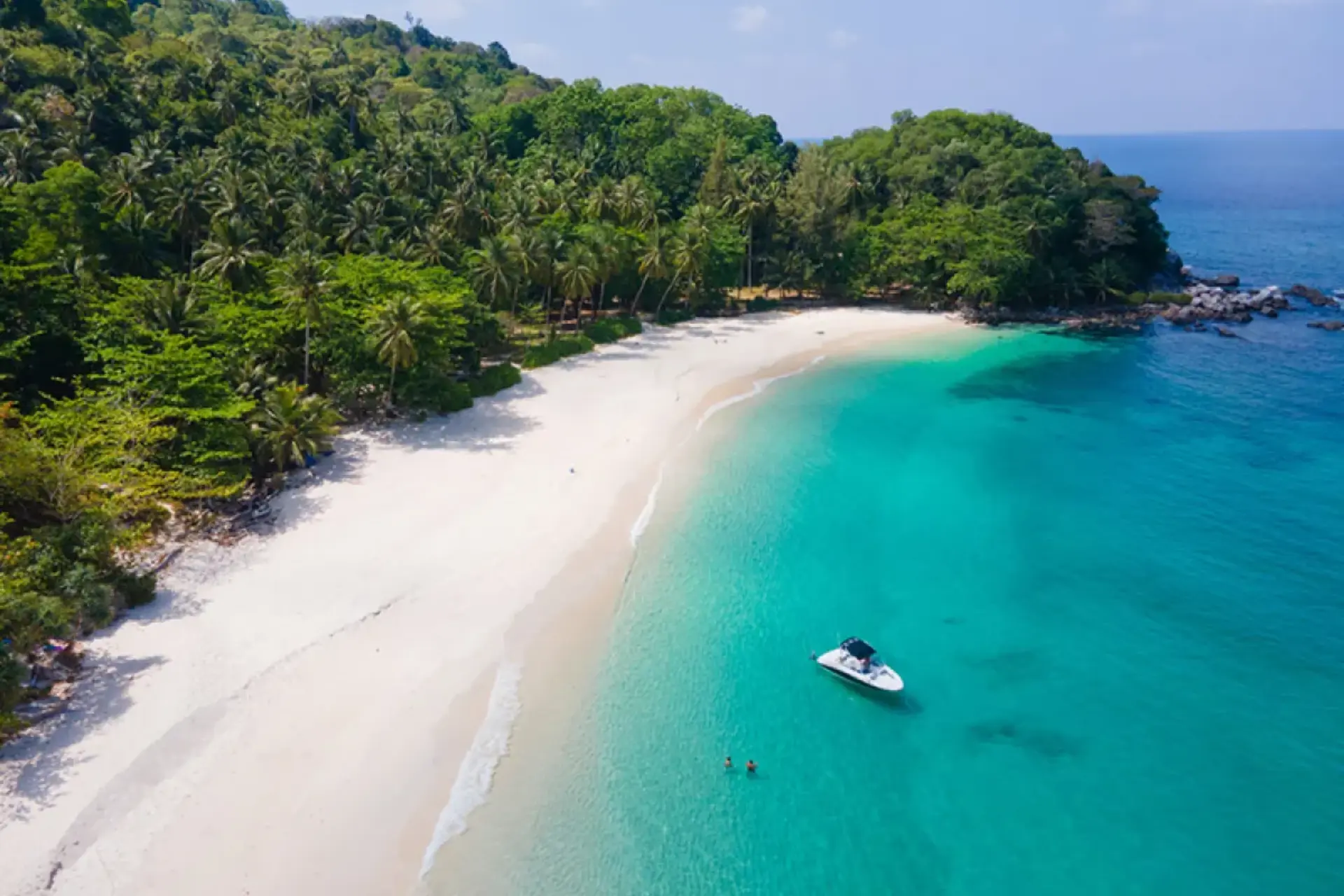 Freedom Beach with white sand, blue-green water, and boat