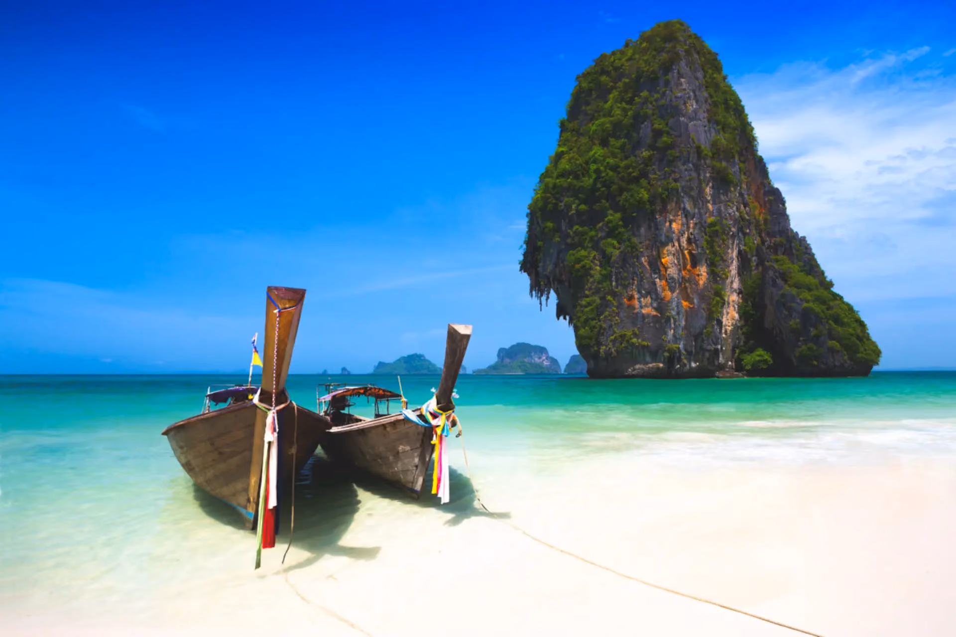 Two wooden boats on white sand beach, Krabi Thailand