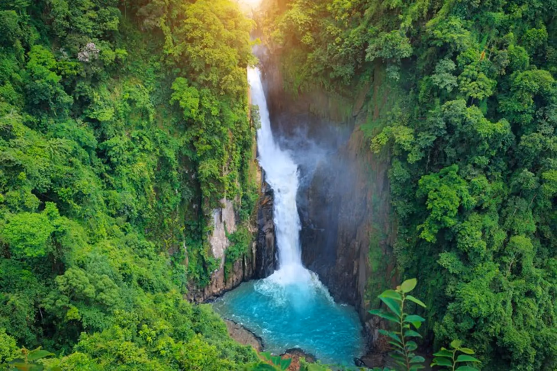 Waterfall flowing into blue-green pool at Khao Yai
