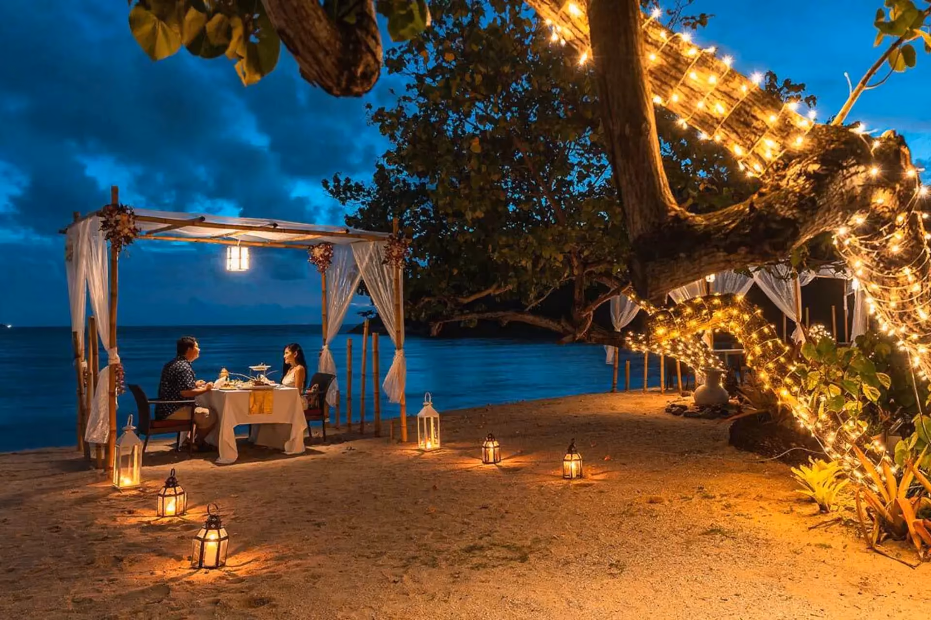 Couple dining on Phuket beach at night
