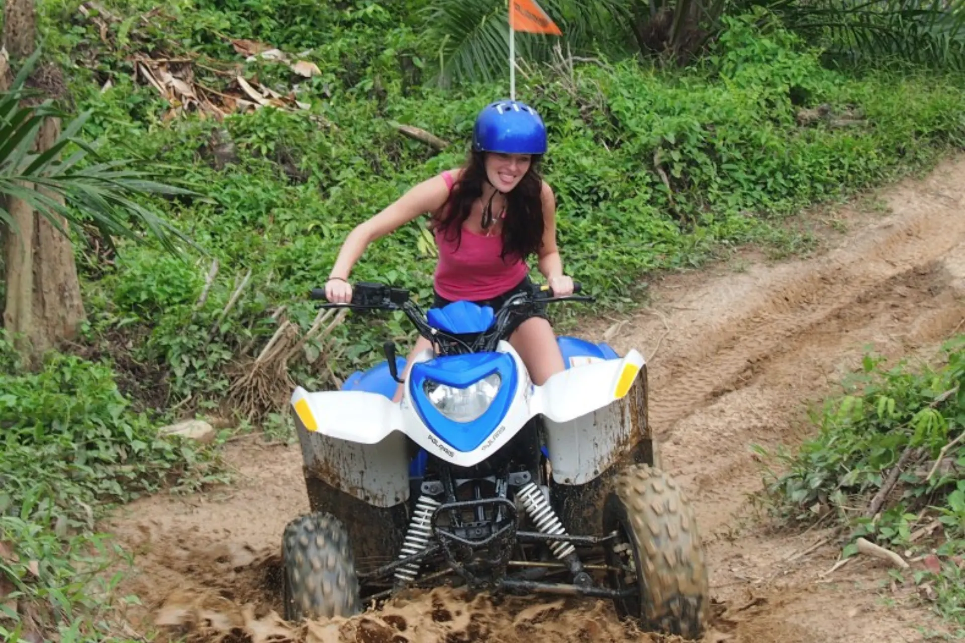 Woman riding blue ATV on dirt trail in Krabi