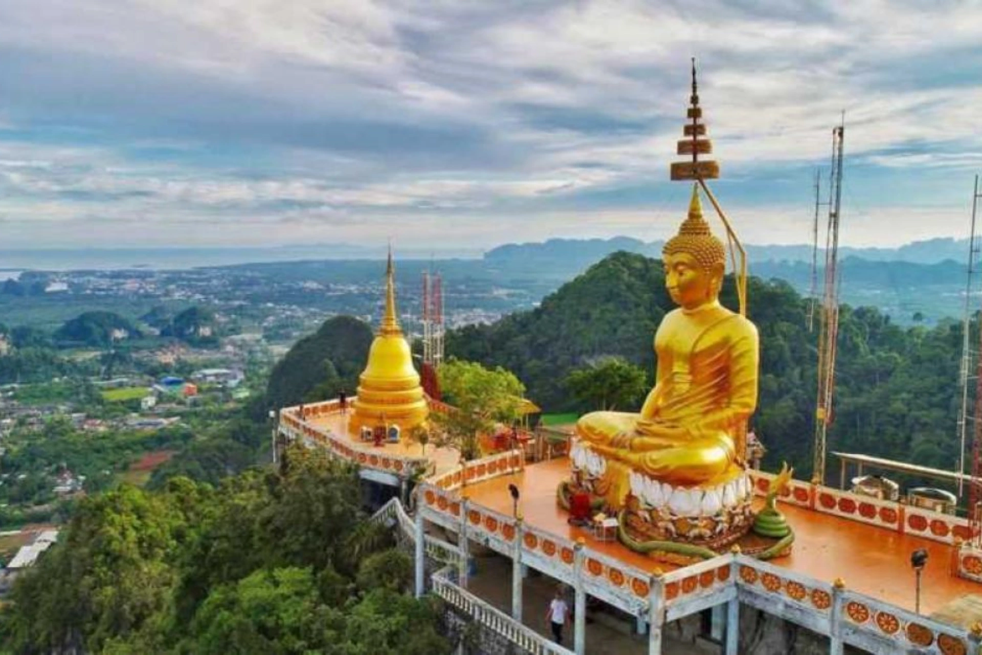 Large gold Buddha statue at Tiger Cave Temple overlooks valley