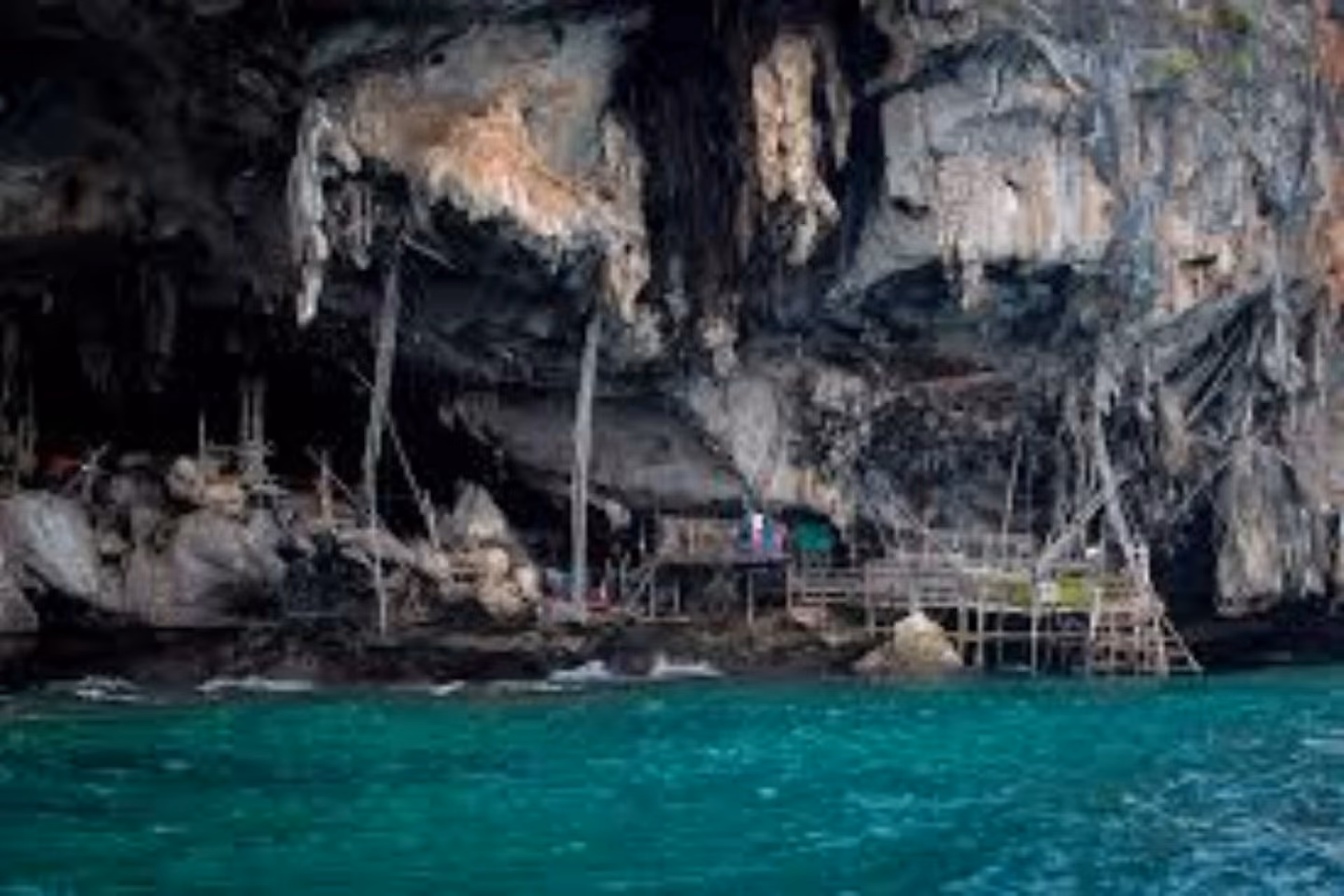 Small wooden shelter built into Viking Cave rocks, Krabi