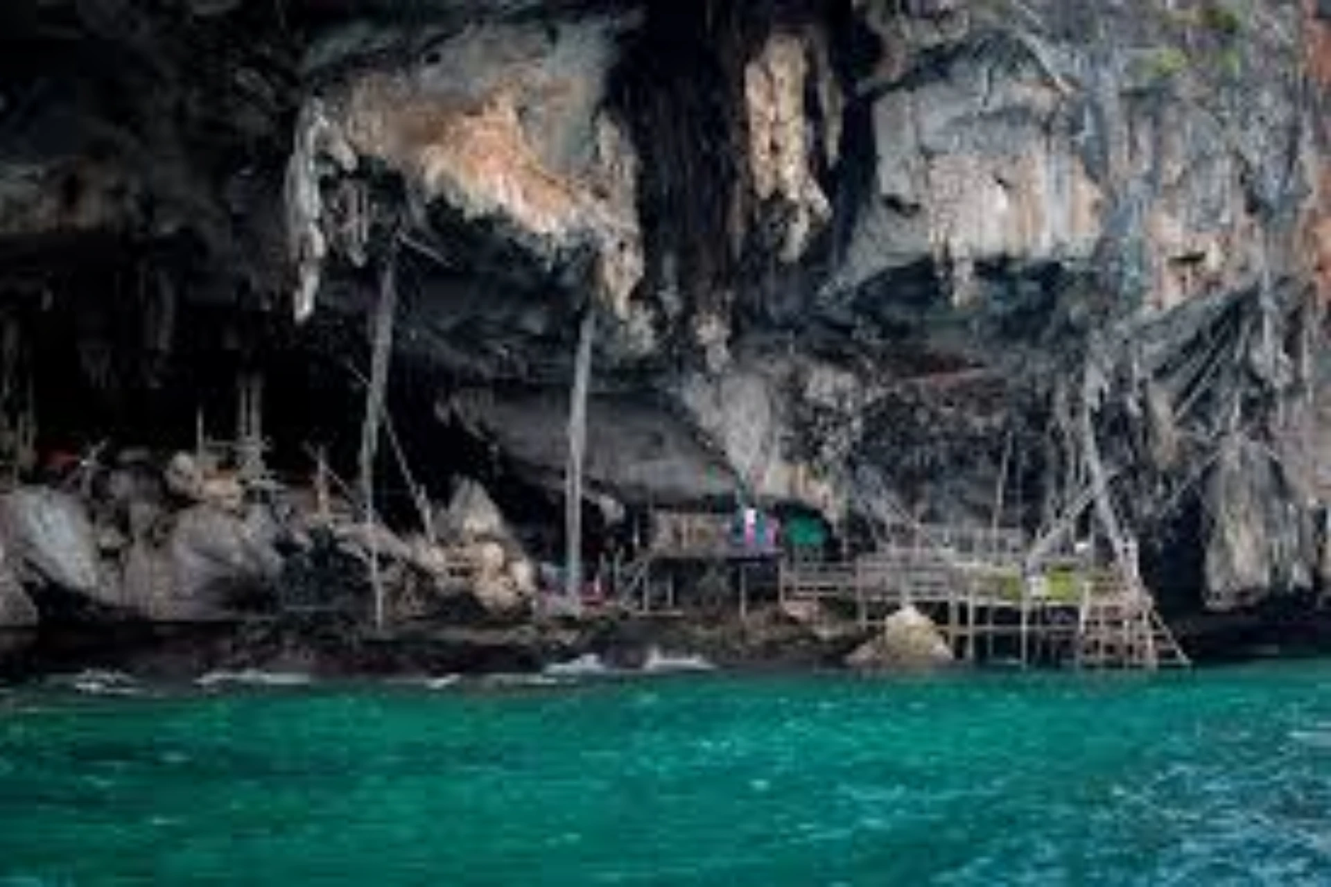 Small wooden shelter built into Viking Cave rocks, Krabi