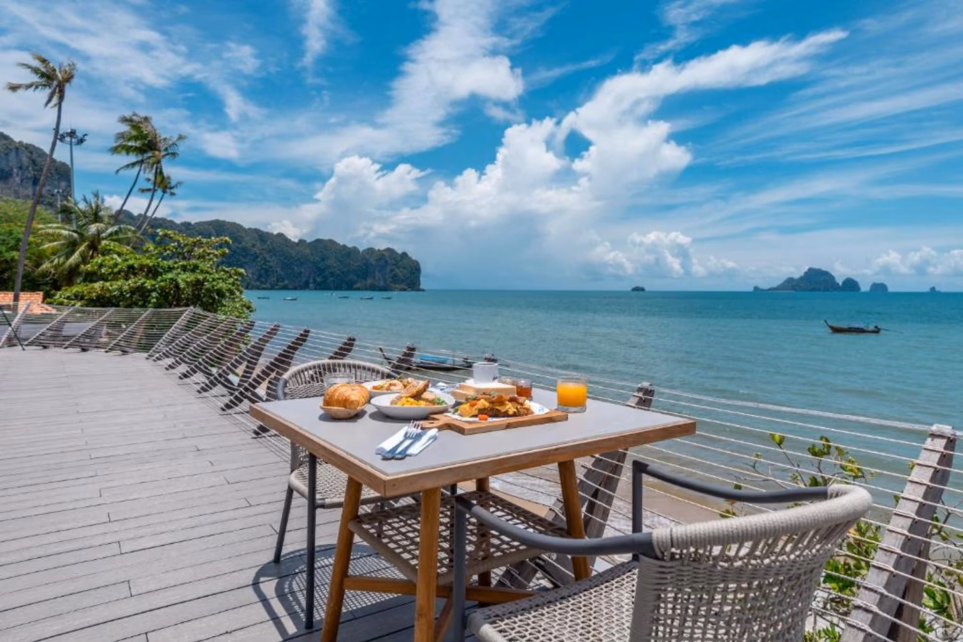 Breakfast table on deck overlooking tropical bay