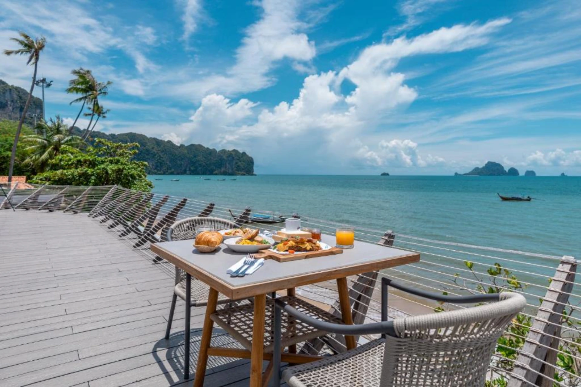 Breakfast table on deck overlooking tropical bay