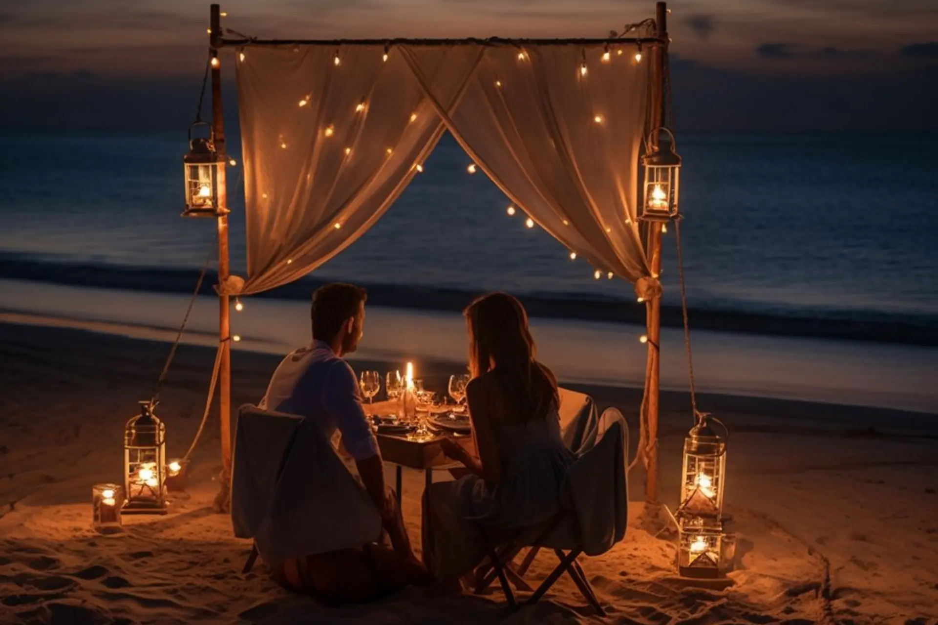 Couple dining by candlelight on Bali beach at sunset
