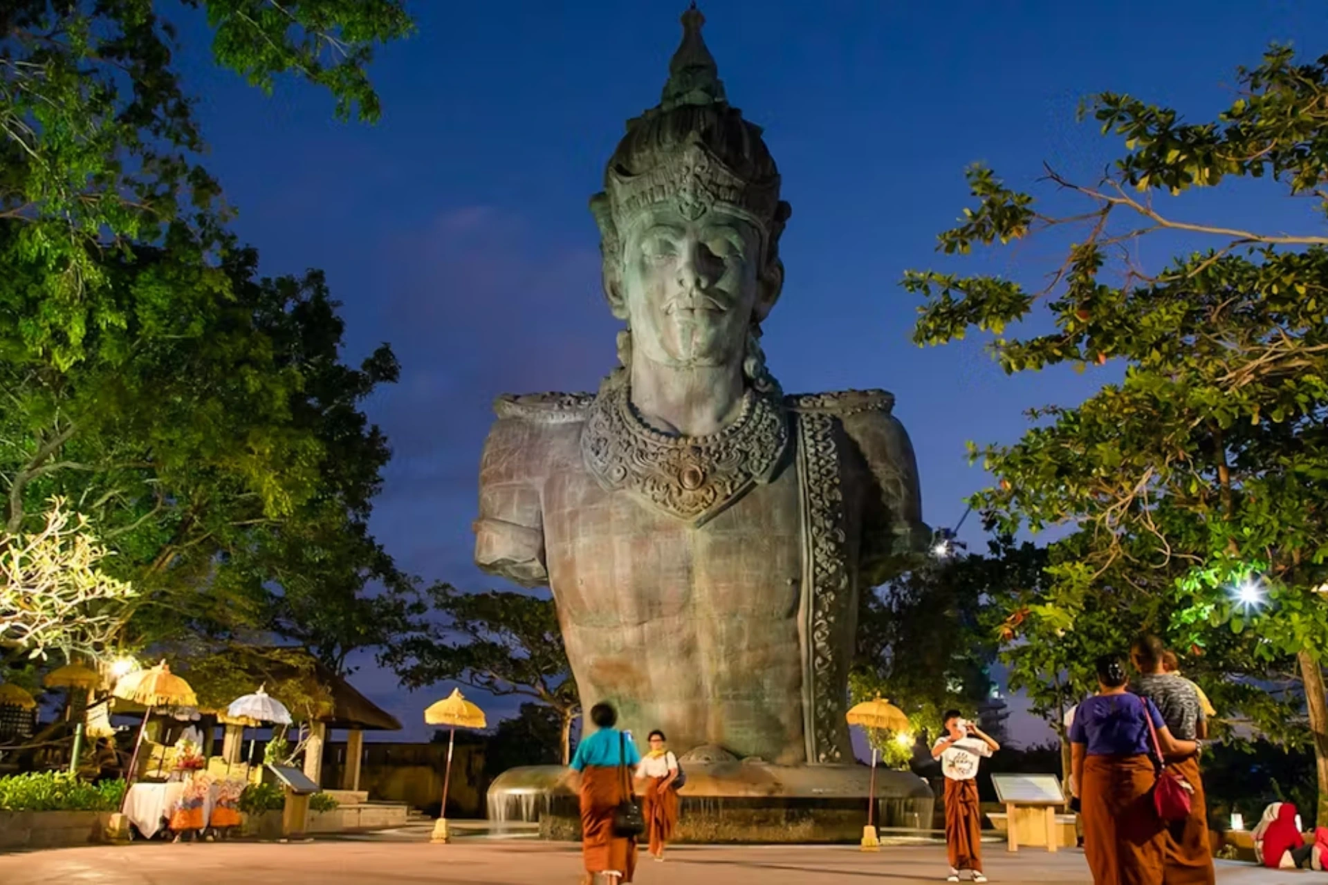 Giant stone statue lit up at night in GWK Park Bali