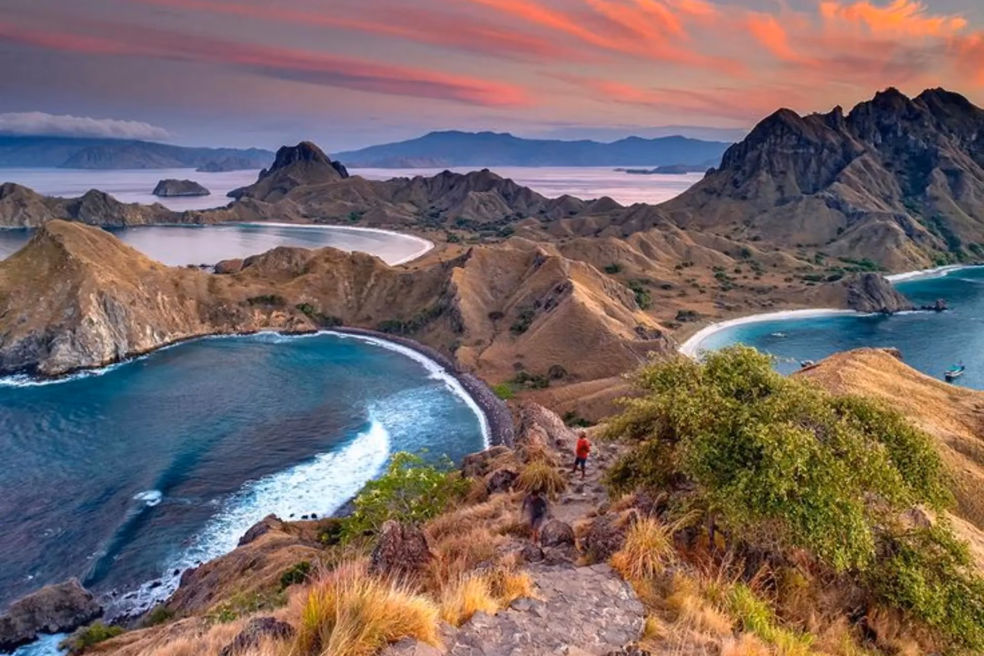 Hiker on mountain overlooking Komodo Island beaches and peaks