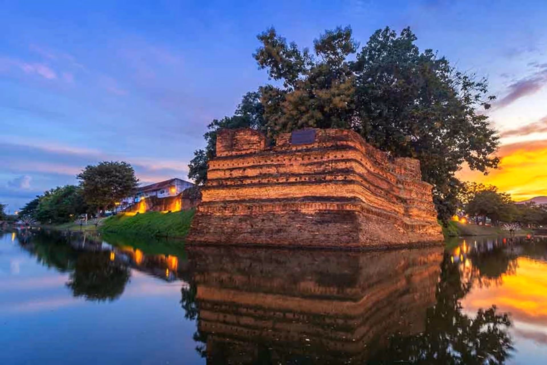Ancient brick tower lit up at sunset in Chiang Mai
