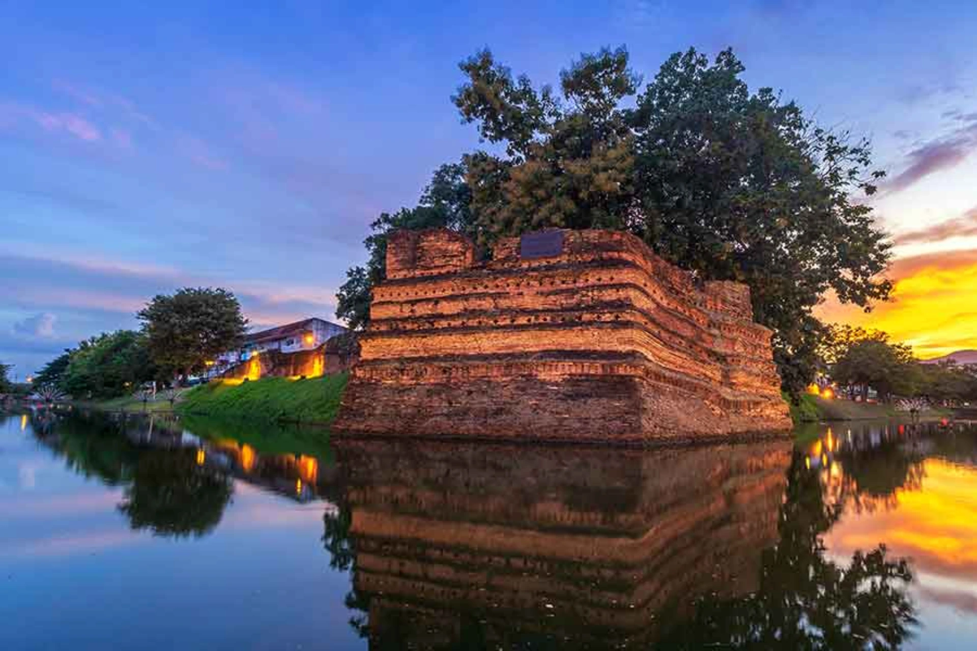 Ancient brick tower lit up at sunset in Chiang Mai