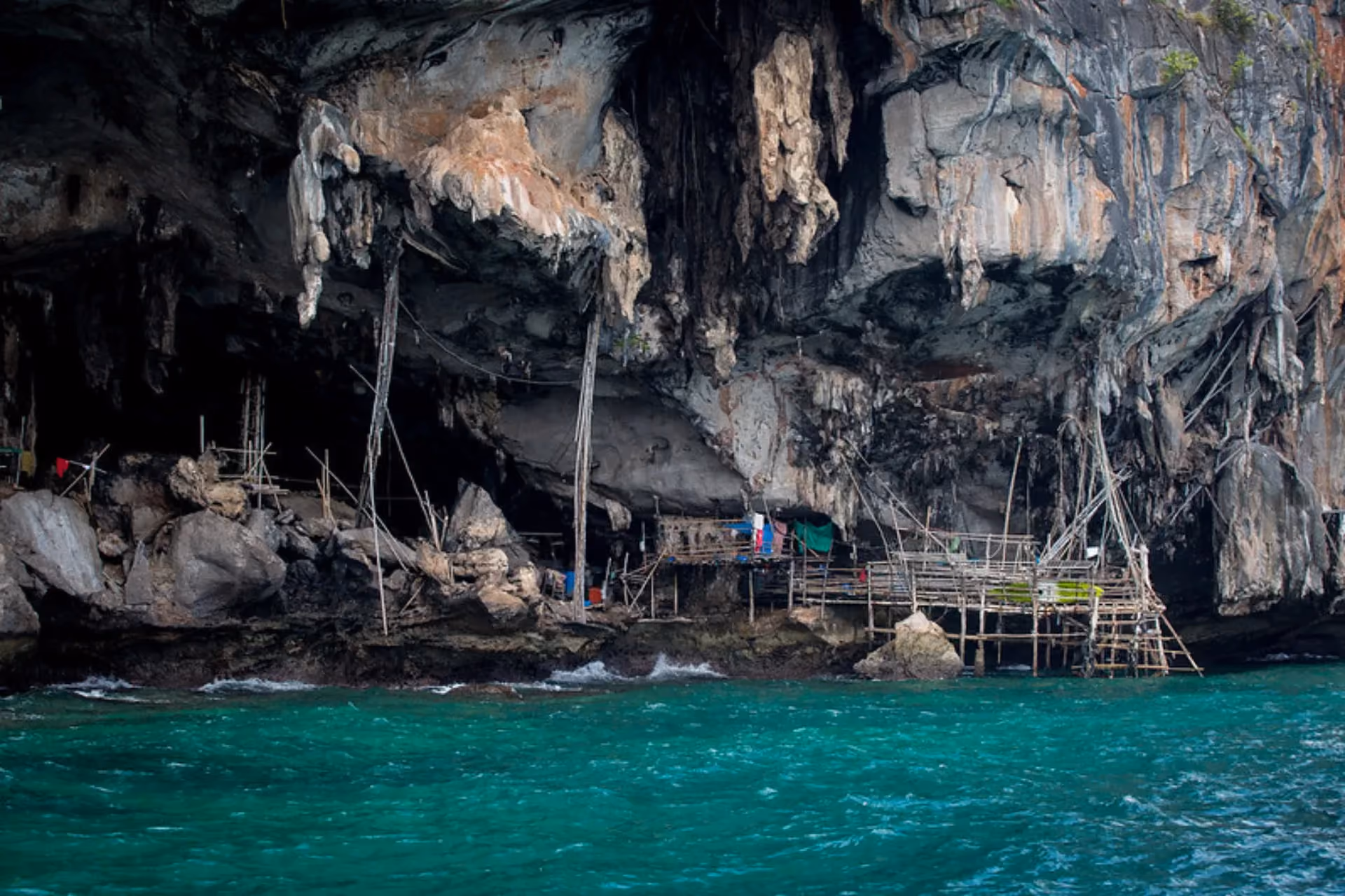 Viking Cave with wooden structures and blue-green water below