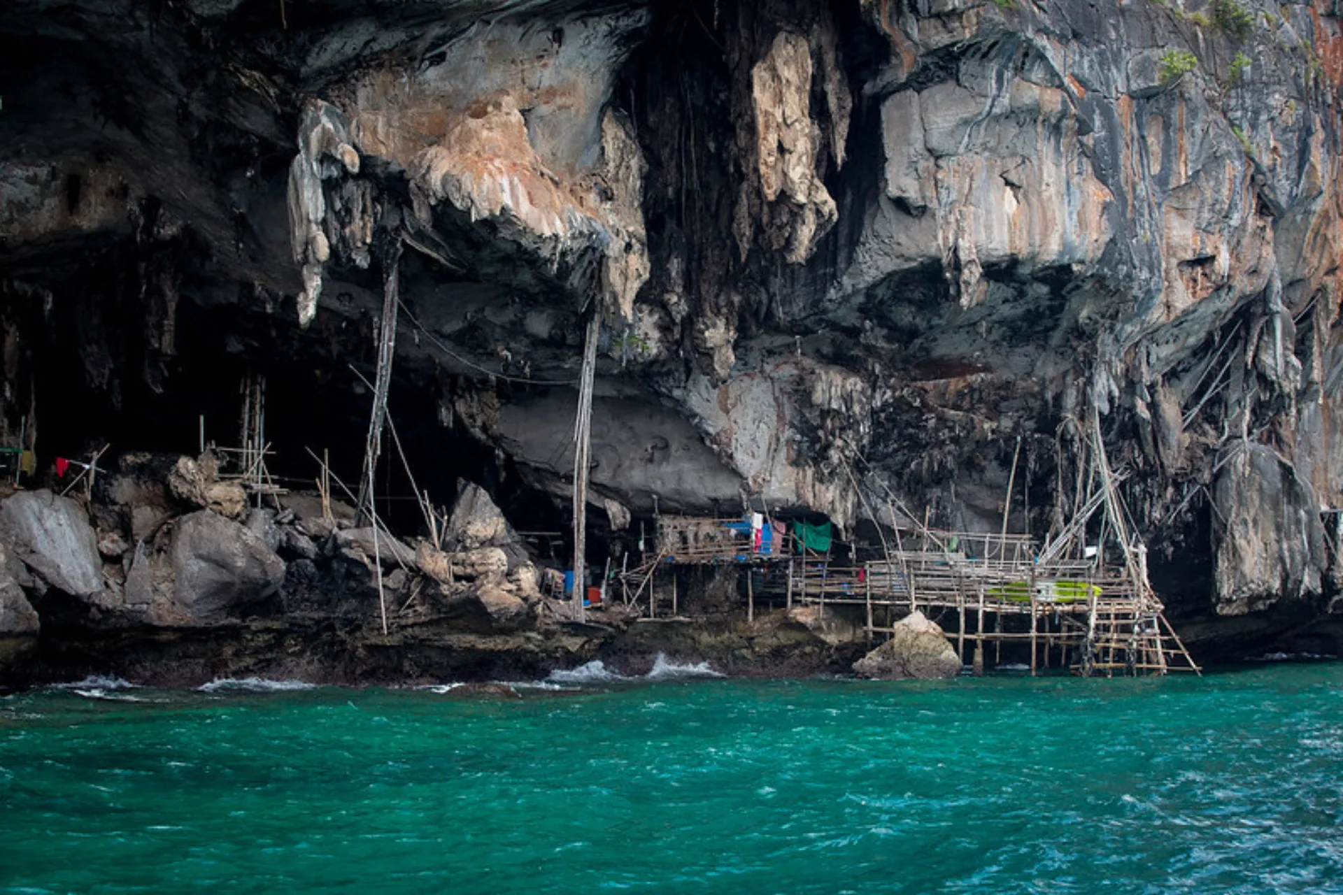 Viking Cave with wooden structures and blue-green water below
