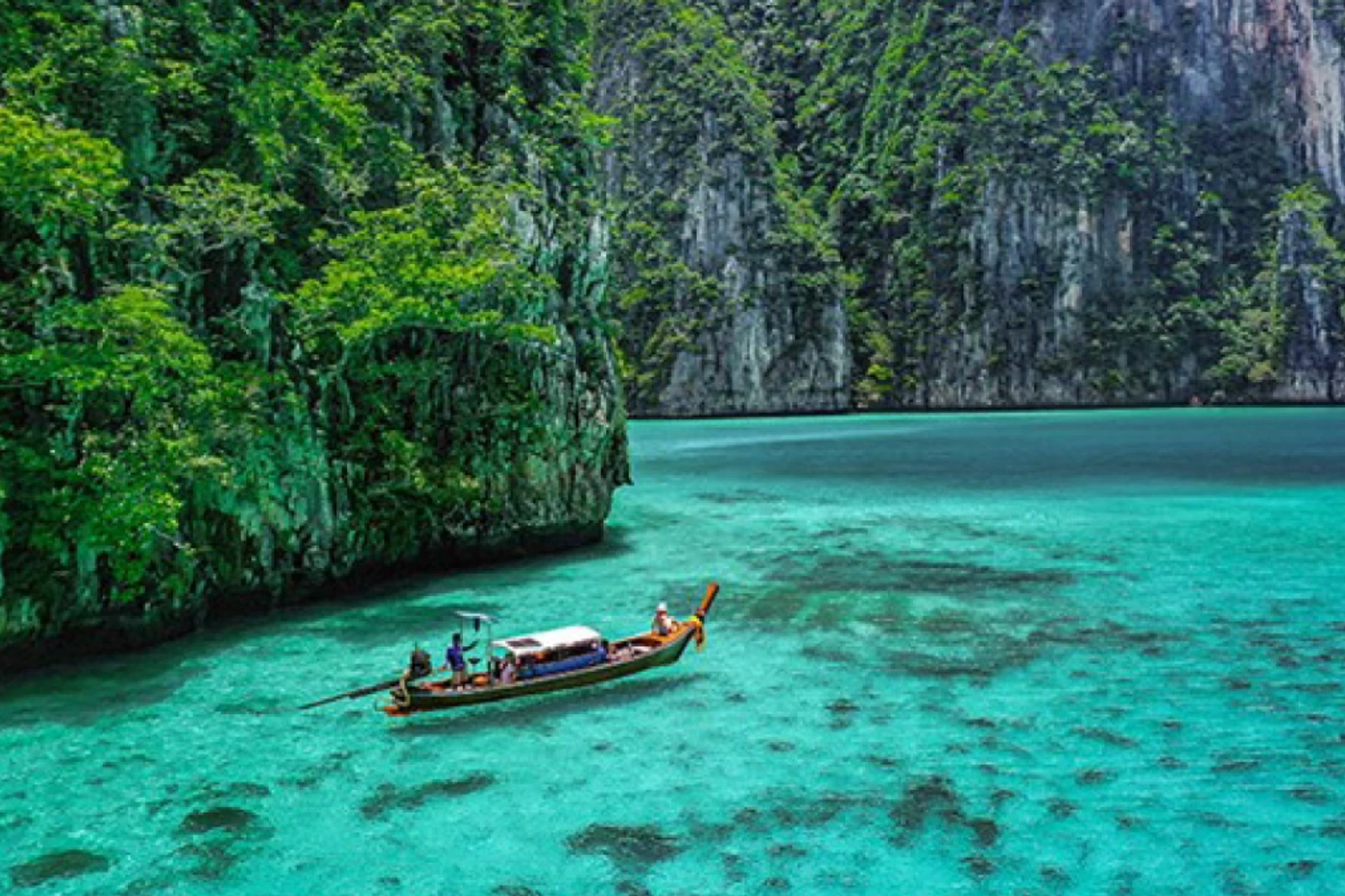 Wooden boat on clear blue-green water at Phi Phi Island