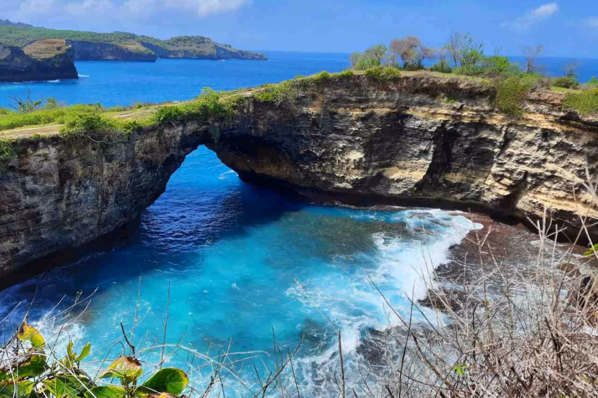 Natural rock arch at Angels Billabong with blue water below