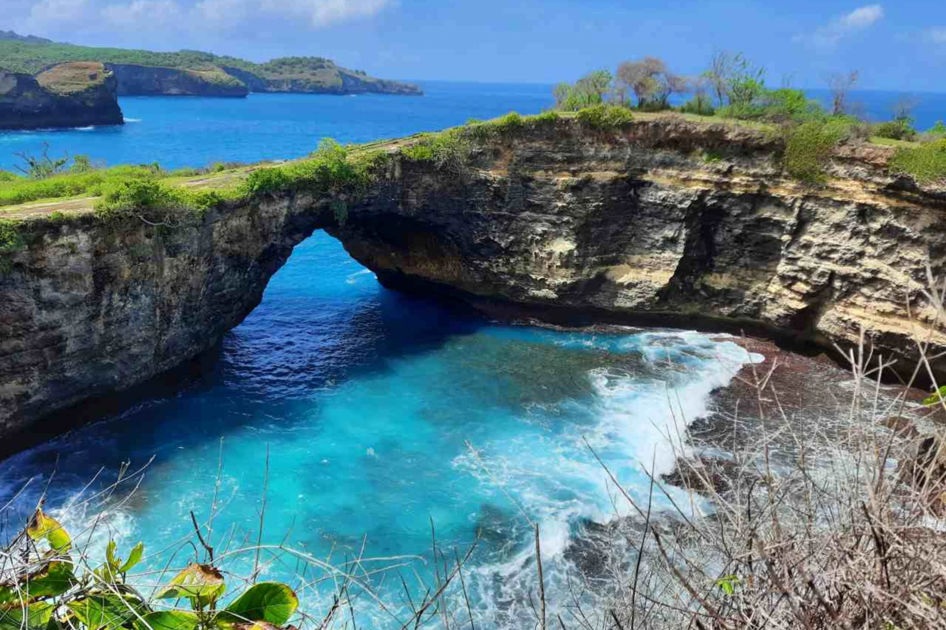 Natural rock arch at Angels Billabong with blue water below