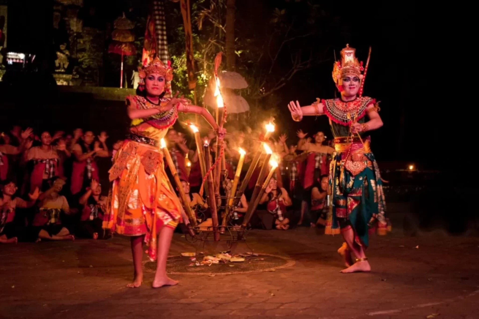 Kecak fire dance performers with lit torches at night