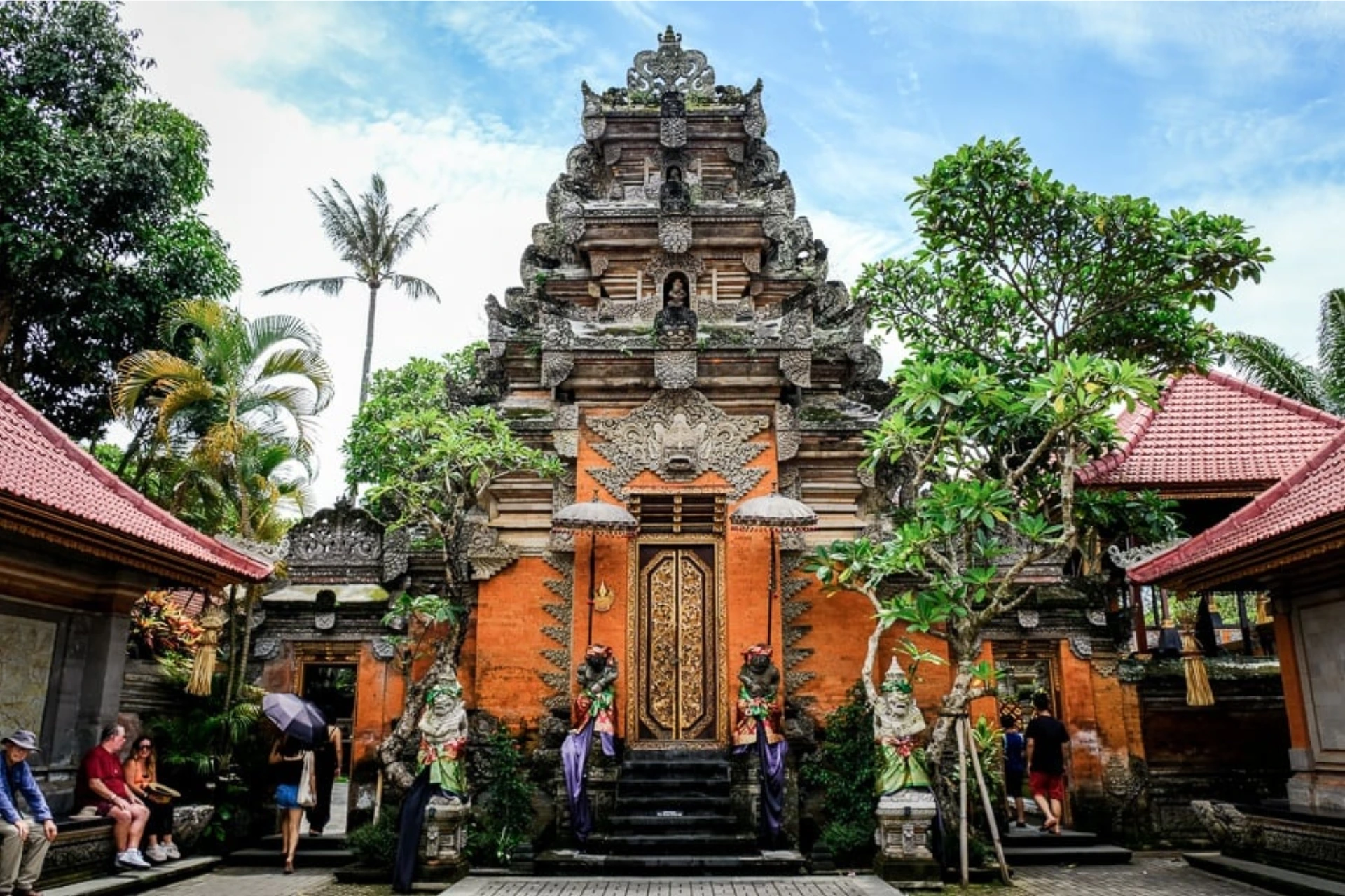 Ornate orange temple with tall stone tower in Ubud Bali