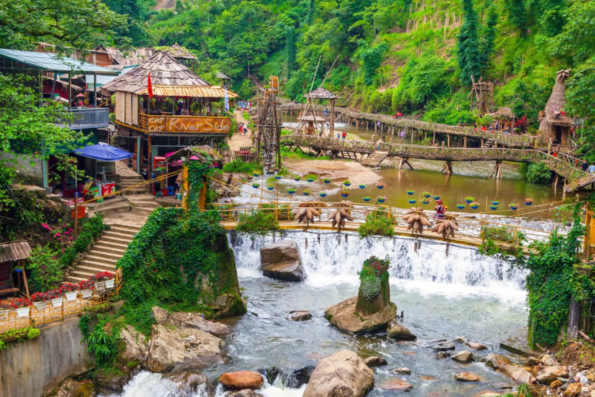 Cat Cat Village waterfall with wooden bridges and buildings