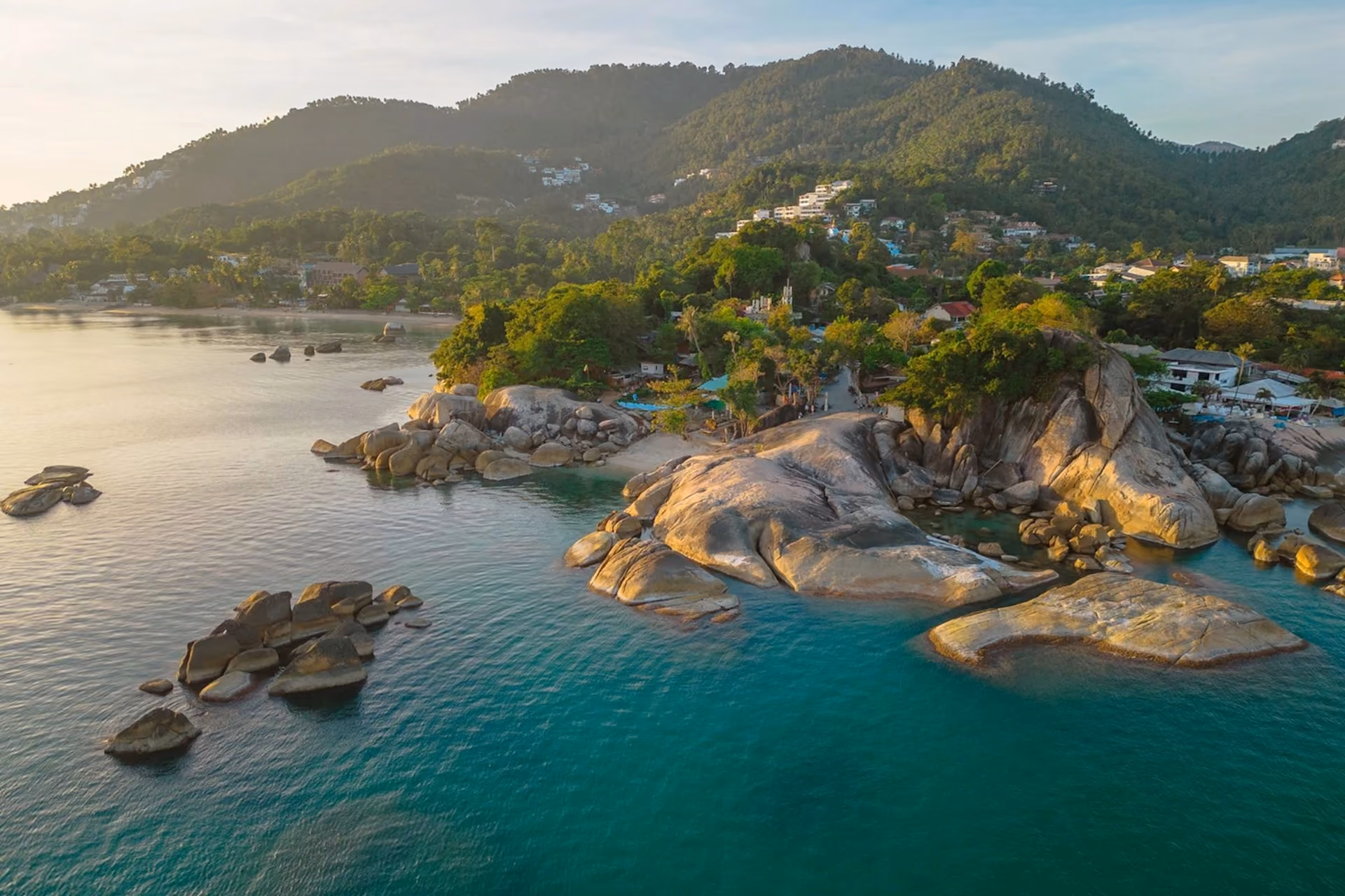 Koh Samui beach with large rocks and green hills