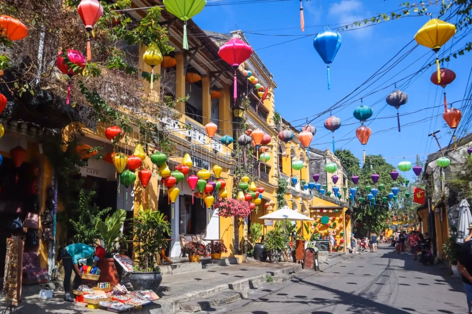 Colorful lanterns hanging over yellow buildings in Hoi An Town
