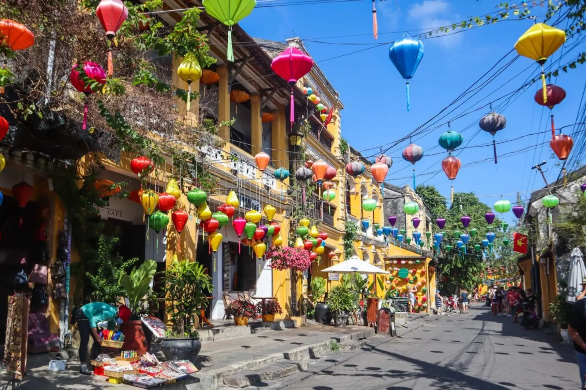 Colorful lanterns hanging over yellow buildings in Hoi An Town