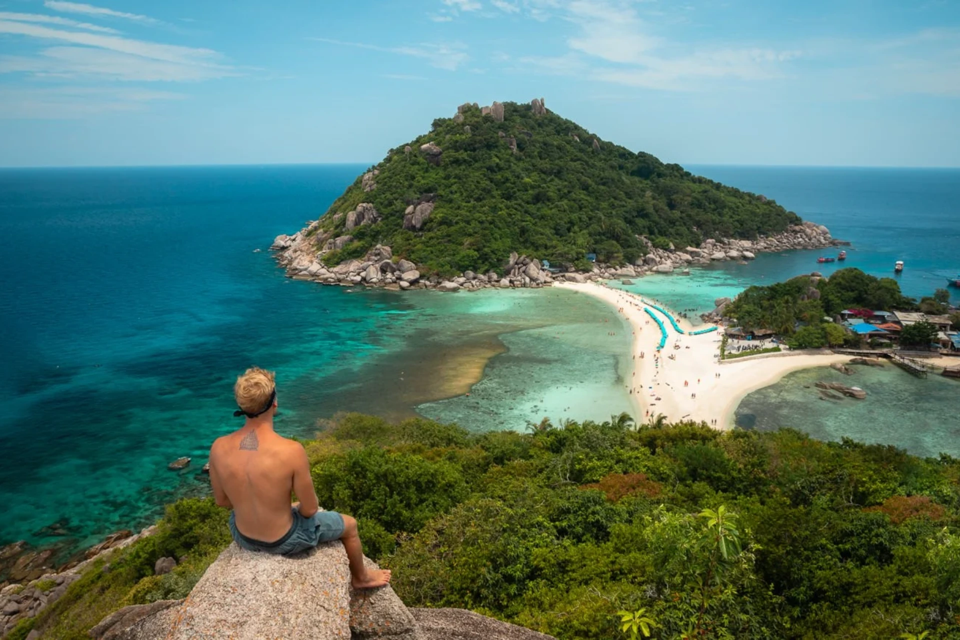 Man sitting on rock overlooking Nang Yuan beach and islands