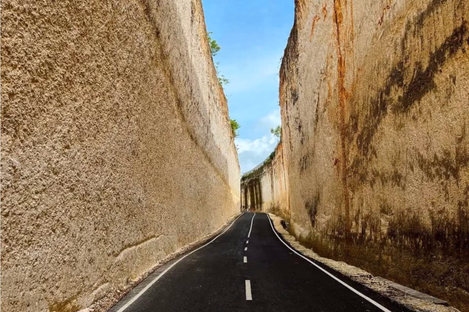 Narrow road between tall stone walls at Pantai Batu Barak