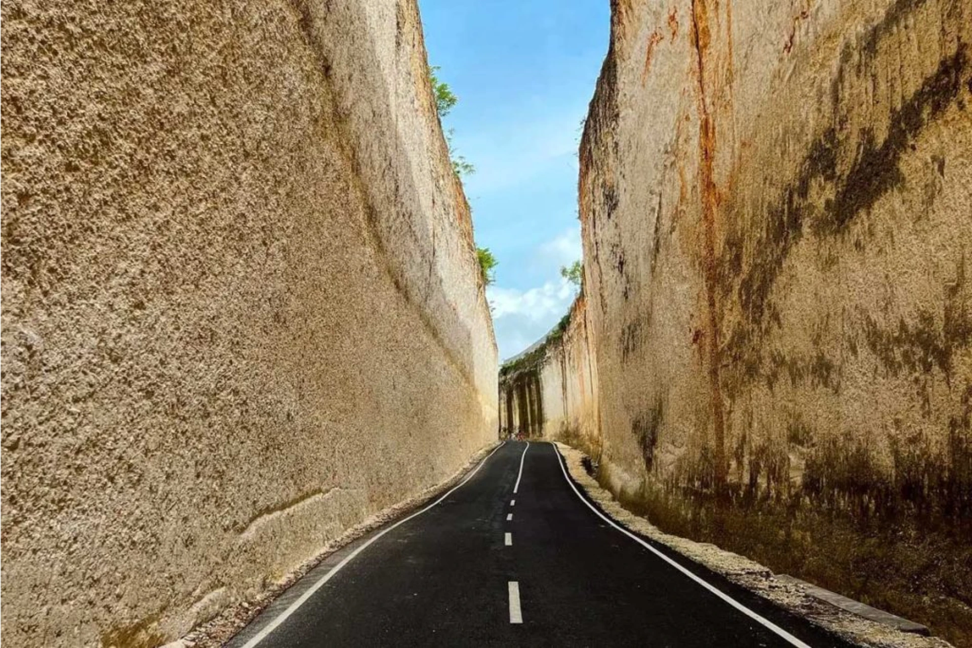 Narrow road between tall stone walls at Pantai Batu Barak