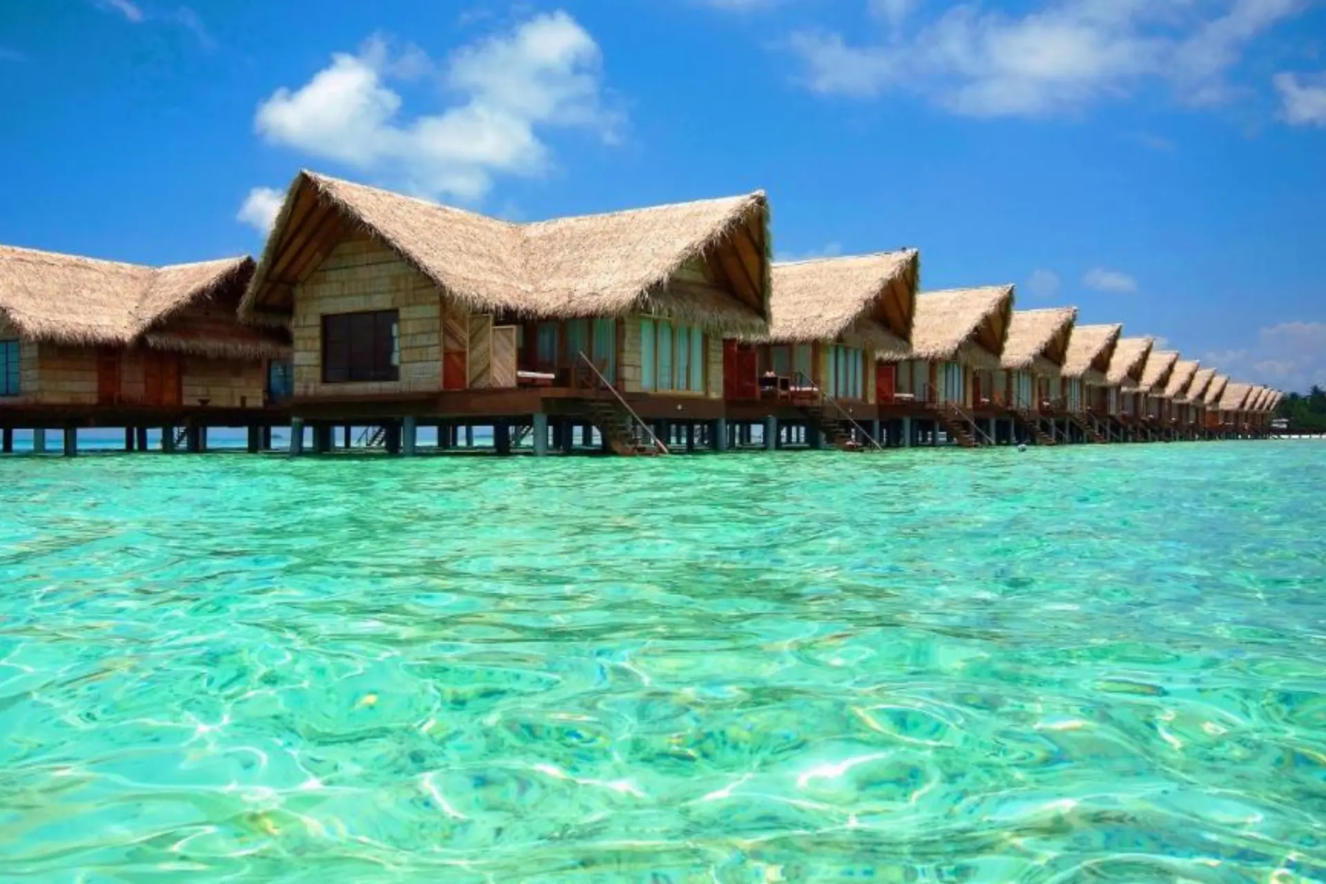 Row of thatched roof bungalows in shallow water at Adaaran Select