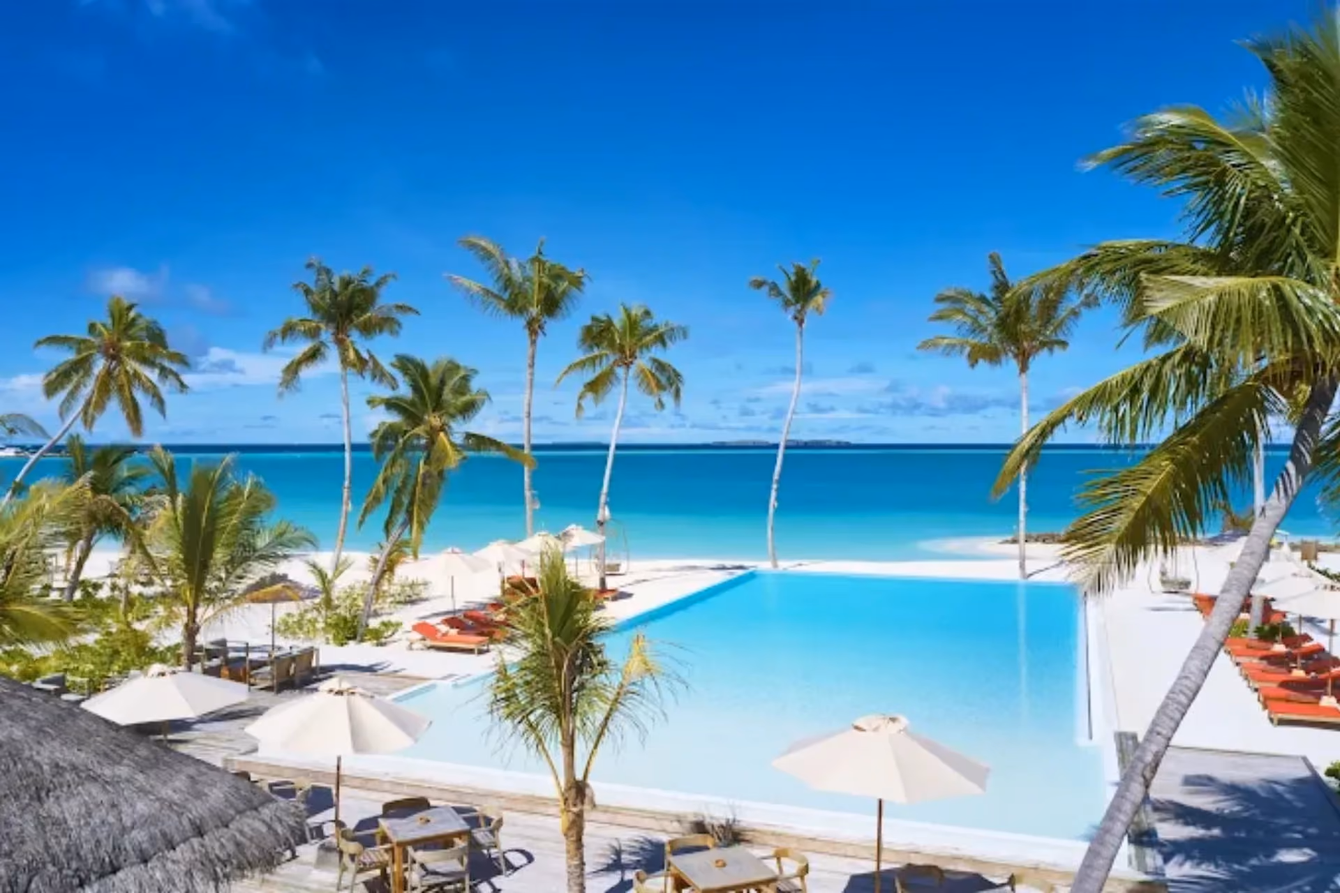 Sun Siyam Iru Veli pool overlooking blue ocean and beach