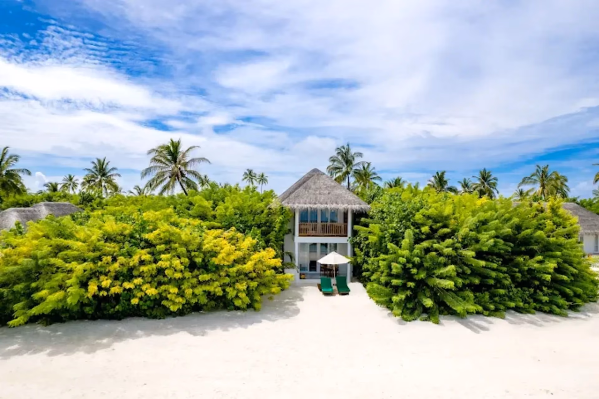 Sun Siyam Iru Veli beach villa with thatched roof and white sand