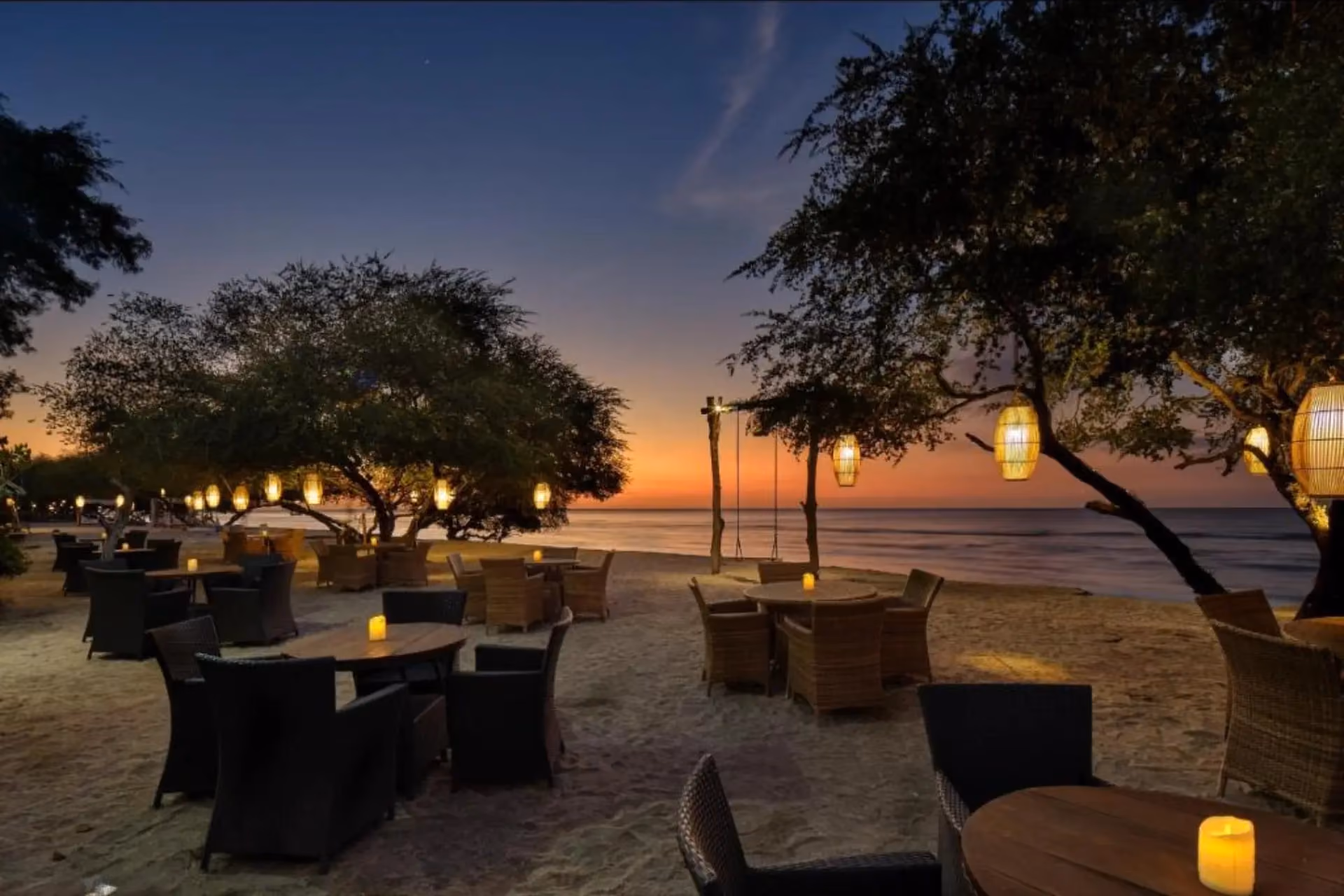Jambuluwuk beach restaurant at sunset with hanging lights