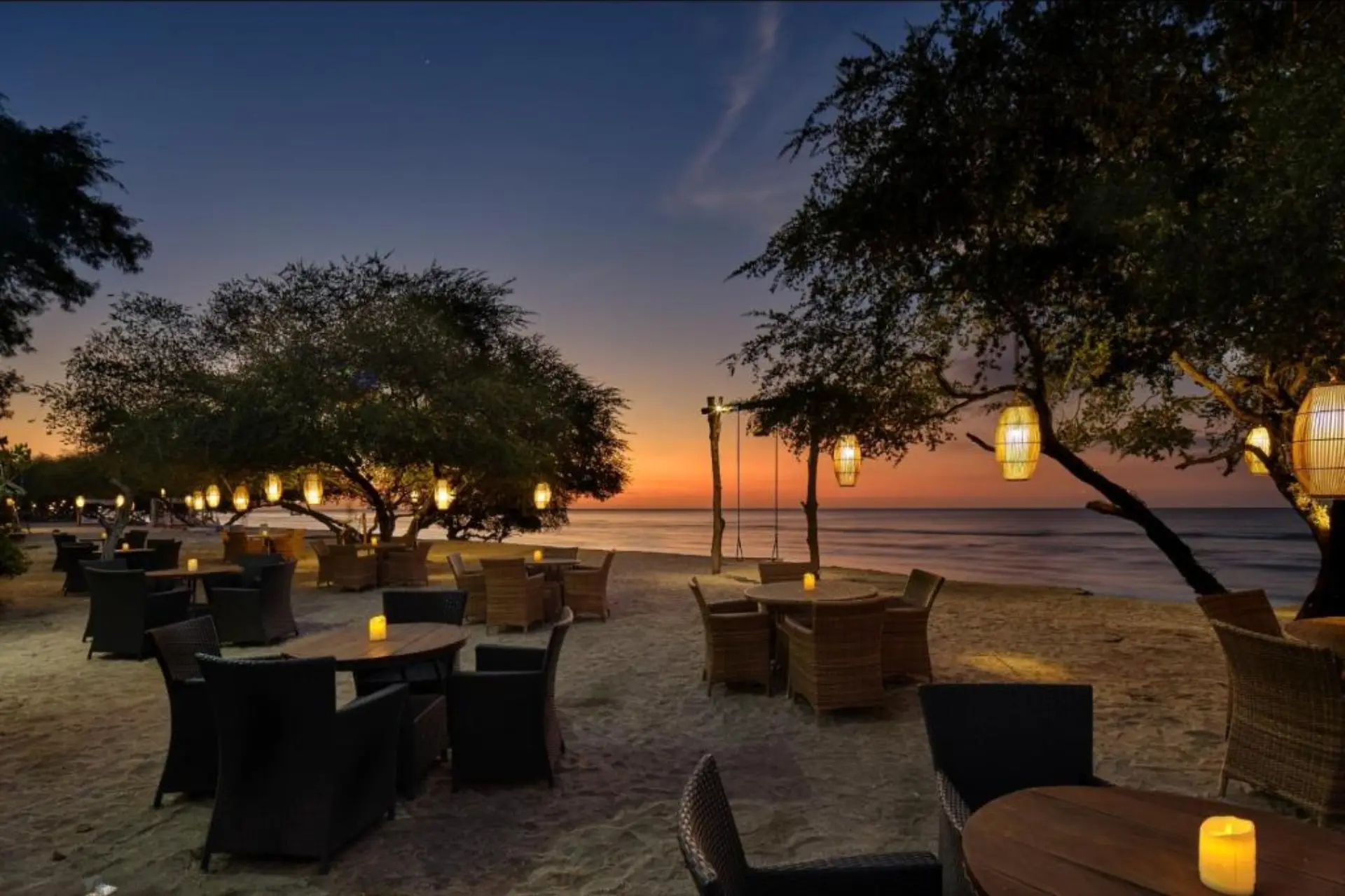 Jambuluwuk beach restaurant at sunset with hanging lights