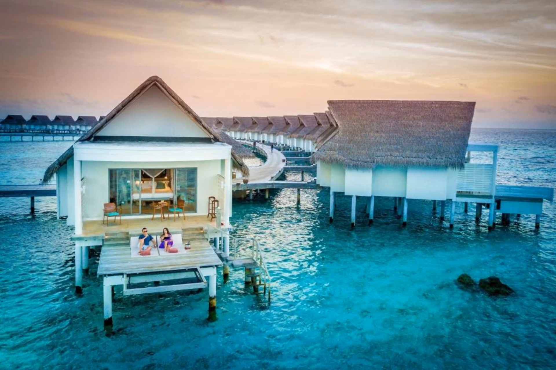 Centara Grand overwater bungalows with blue-green water and sunset sky